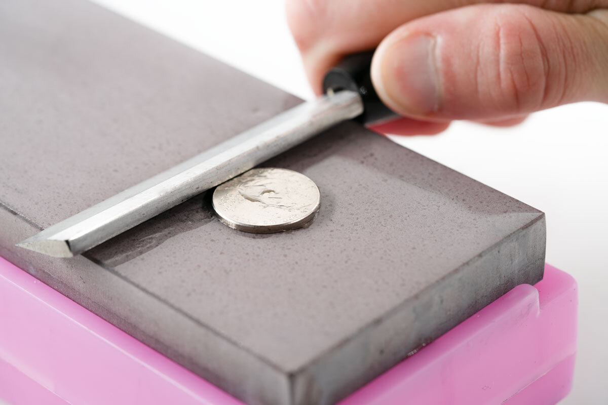 figure 5 Figure 6. Photo of a reed knife lifted off the sharpening stone to the height of a nickel.